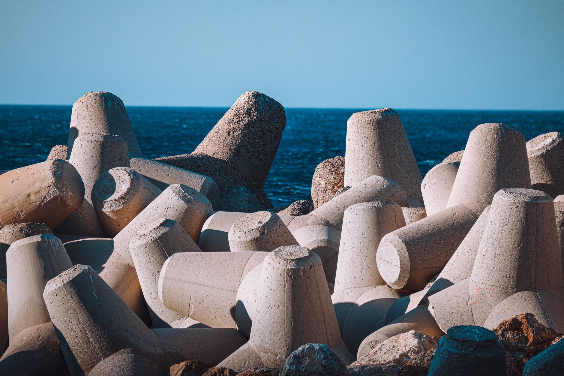 Concrete armour units on a breakwater beside the sea