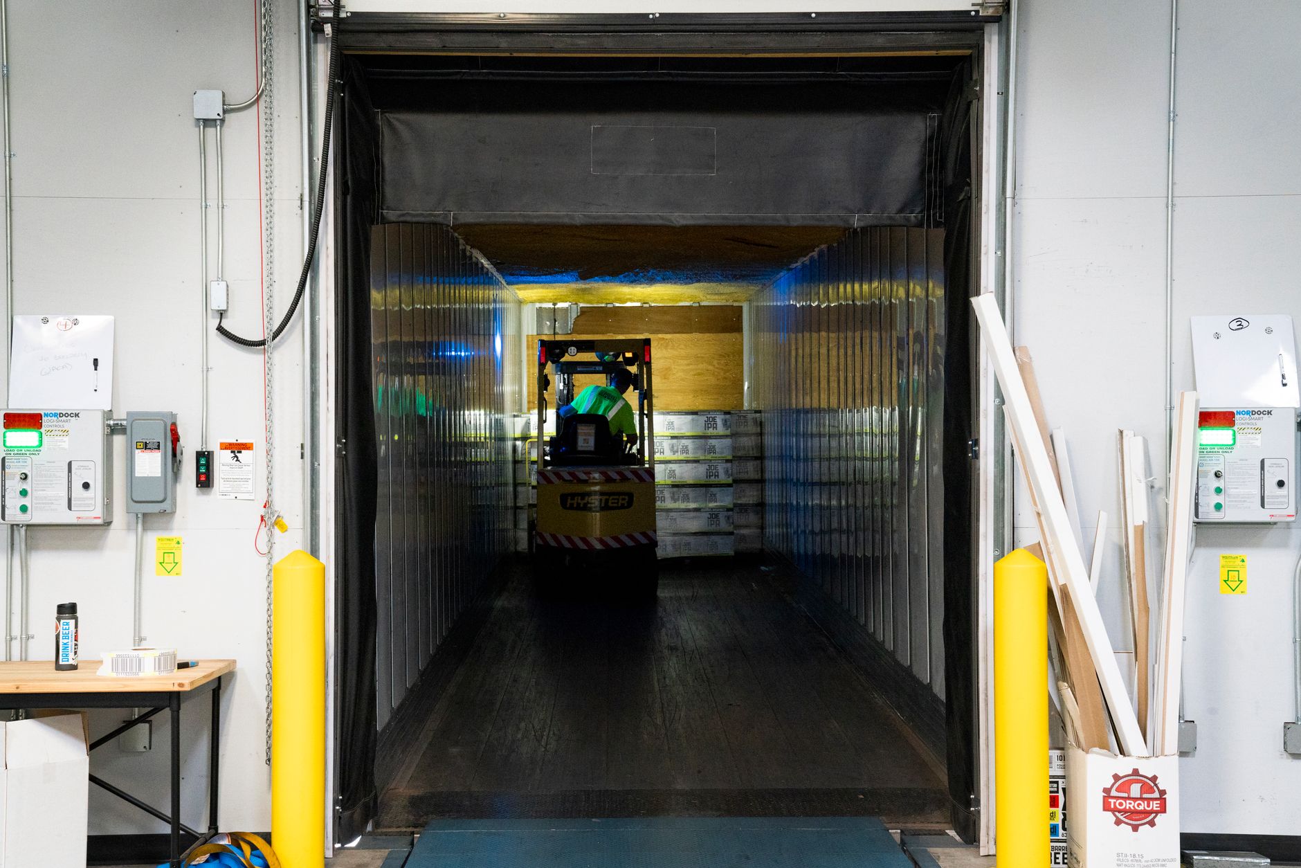 Forklift loading palletized goods at a warehouse dock