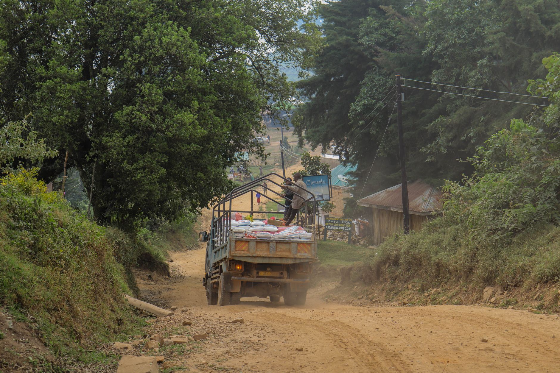 Truck loaded with sacks driving along an unpaved dirt road