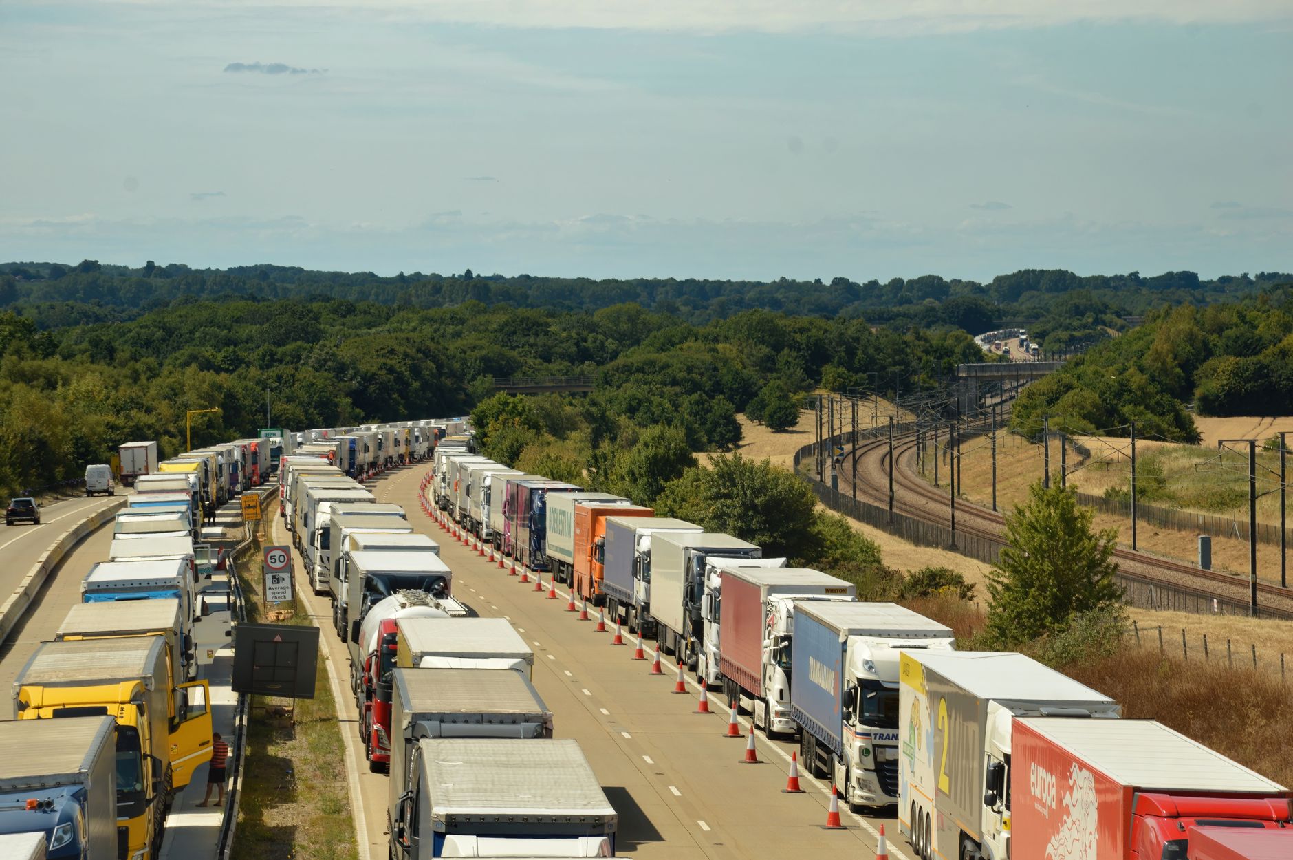A long queue of freight trucks waiting on a road