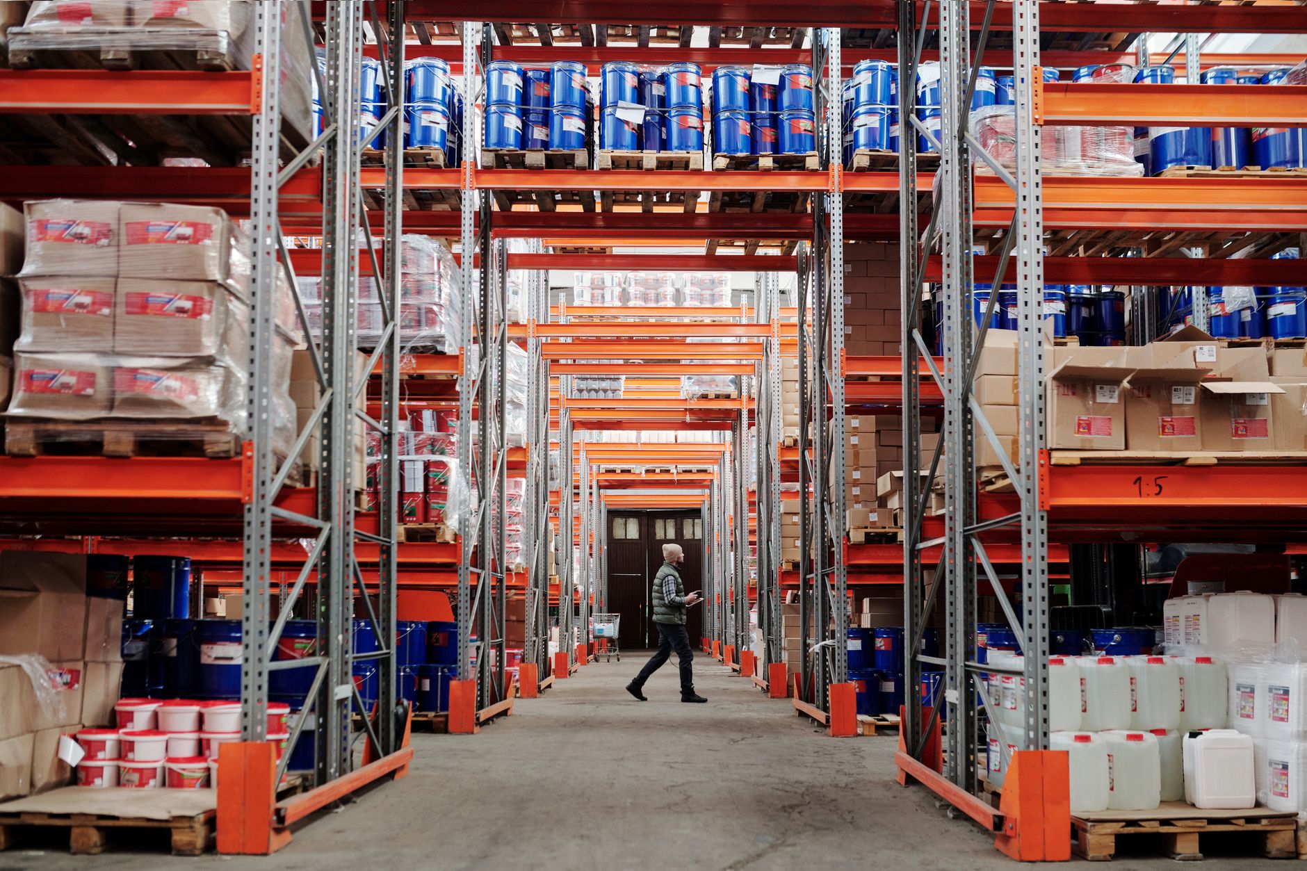 Warehouse workers moving palletised goods along a racking aisle