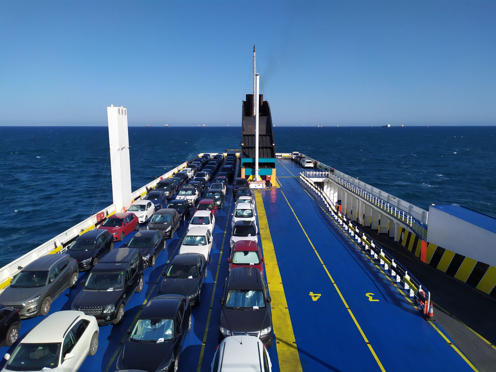 Cars loaded on the open deck of a roll-on roll-off vehicle carrier at sea