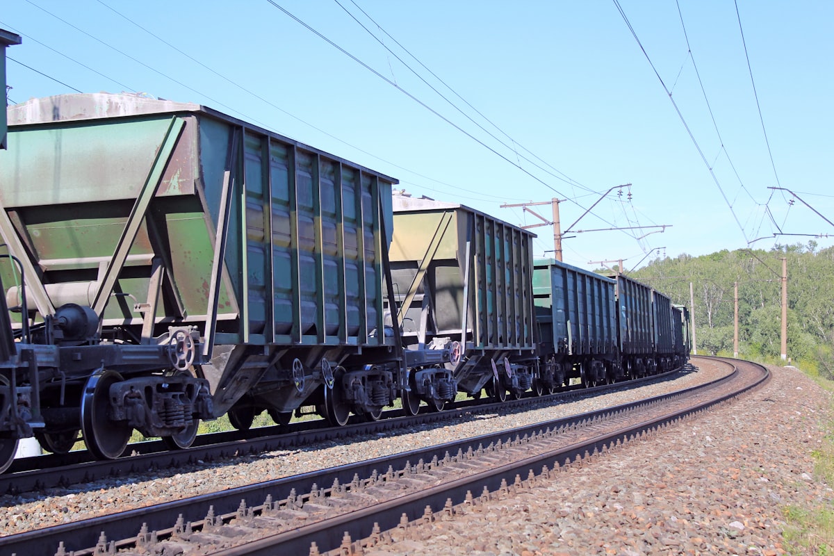 Loaded freight train on an electrified main line curving through open country