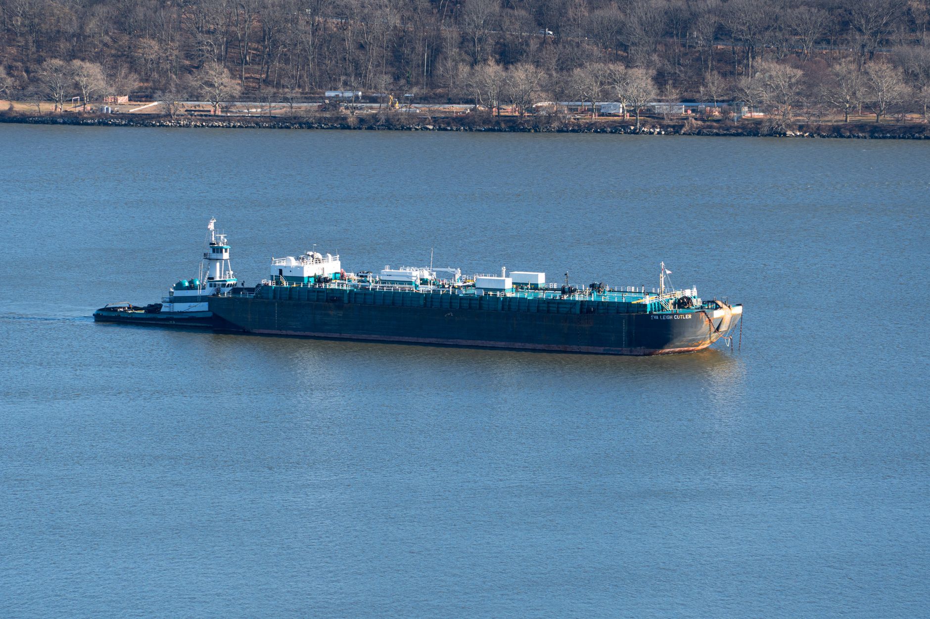 Tank barge under push-tow moving along a river