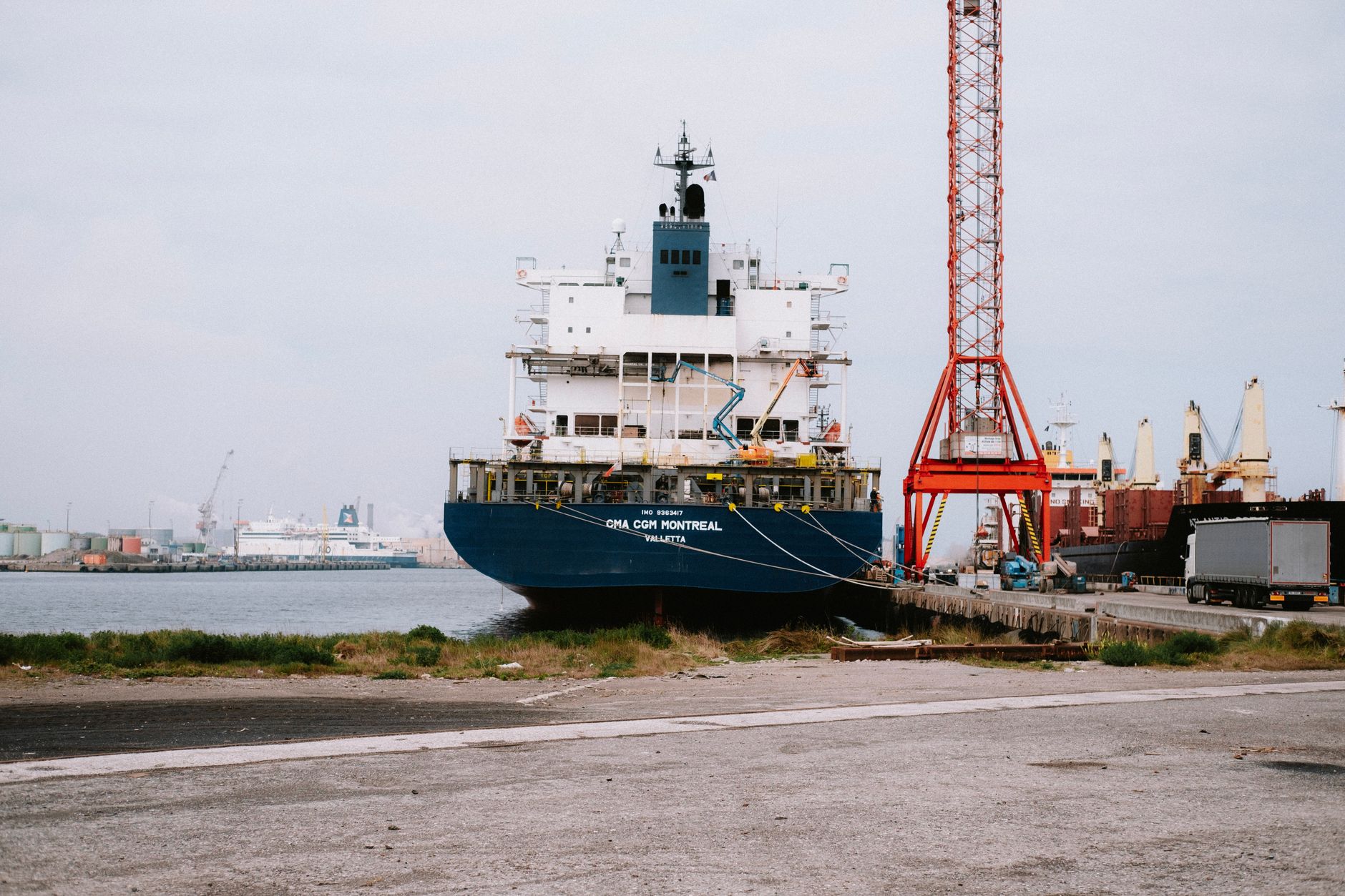 Stern of a container ship at a quay showing its port of registry under the ship name
