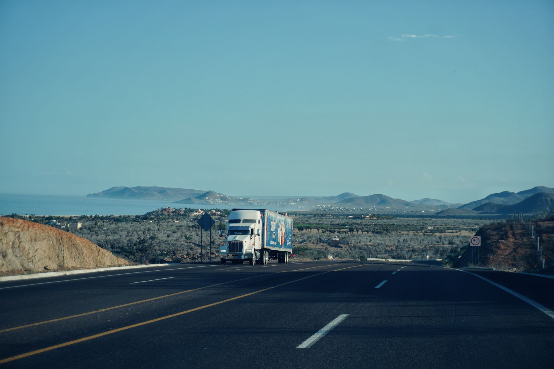Long-haul freight truck on an open highway stretching to the horizon