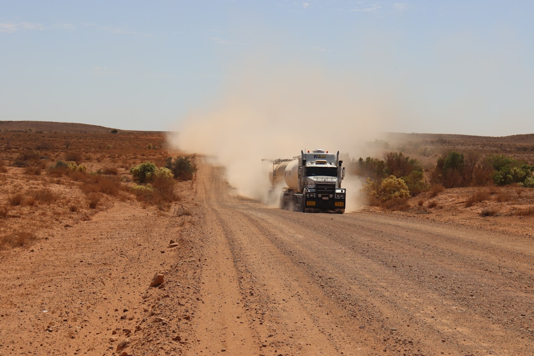 Tanker road train raising dust on an unsealed outback road