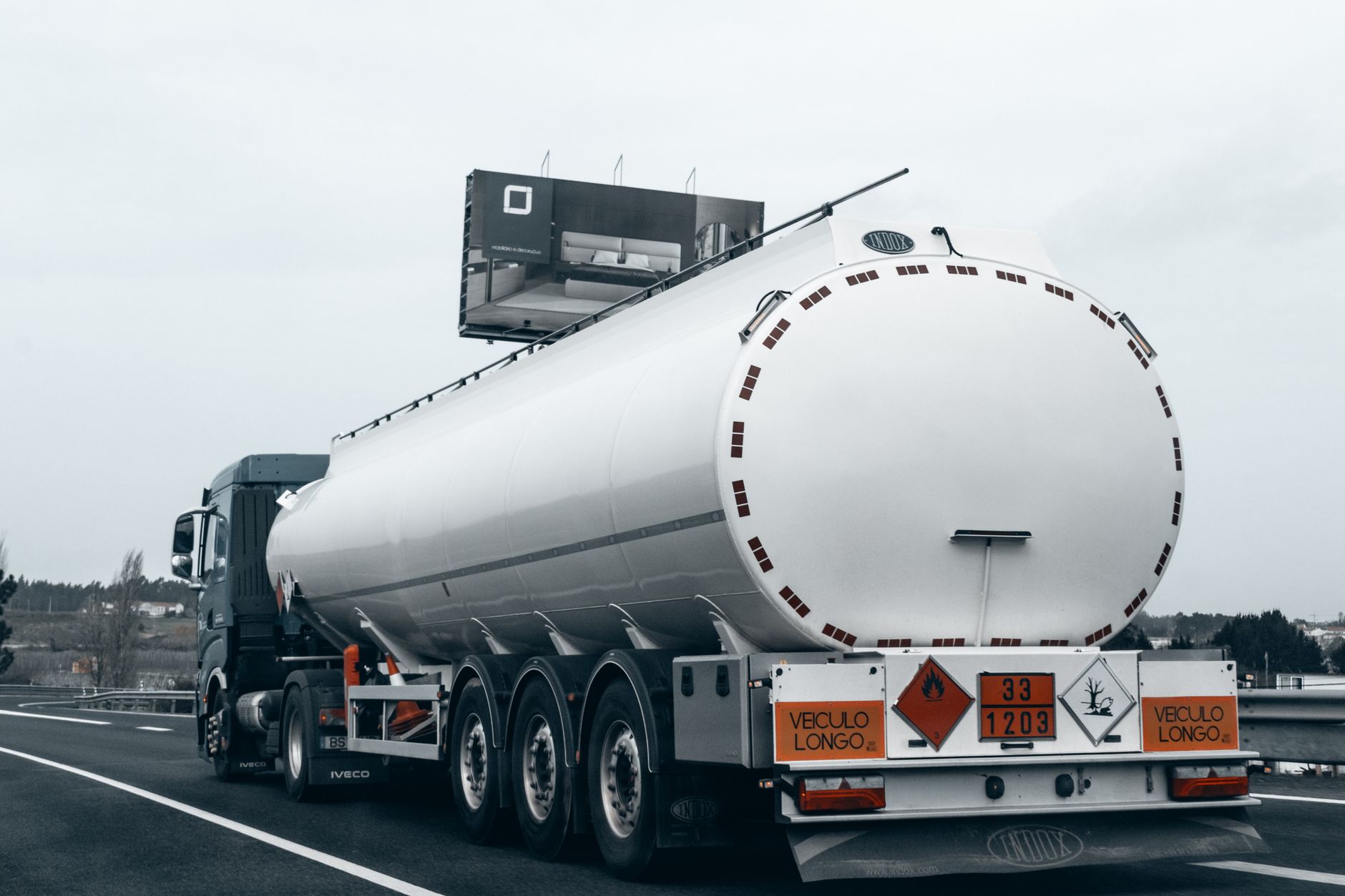 Road tanker on a motorway carrying an orange dangerous-goods plate and a class 3 flammable label