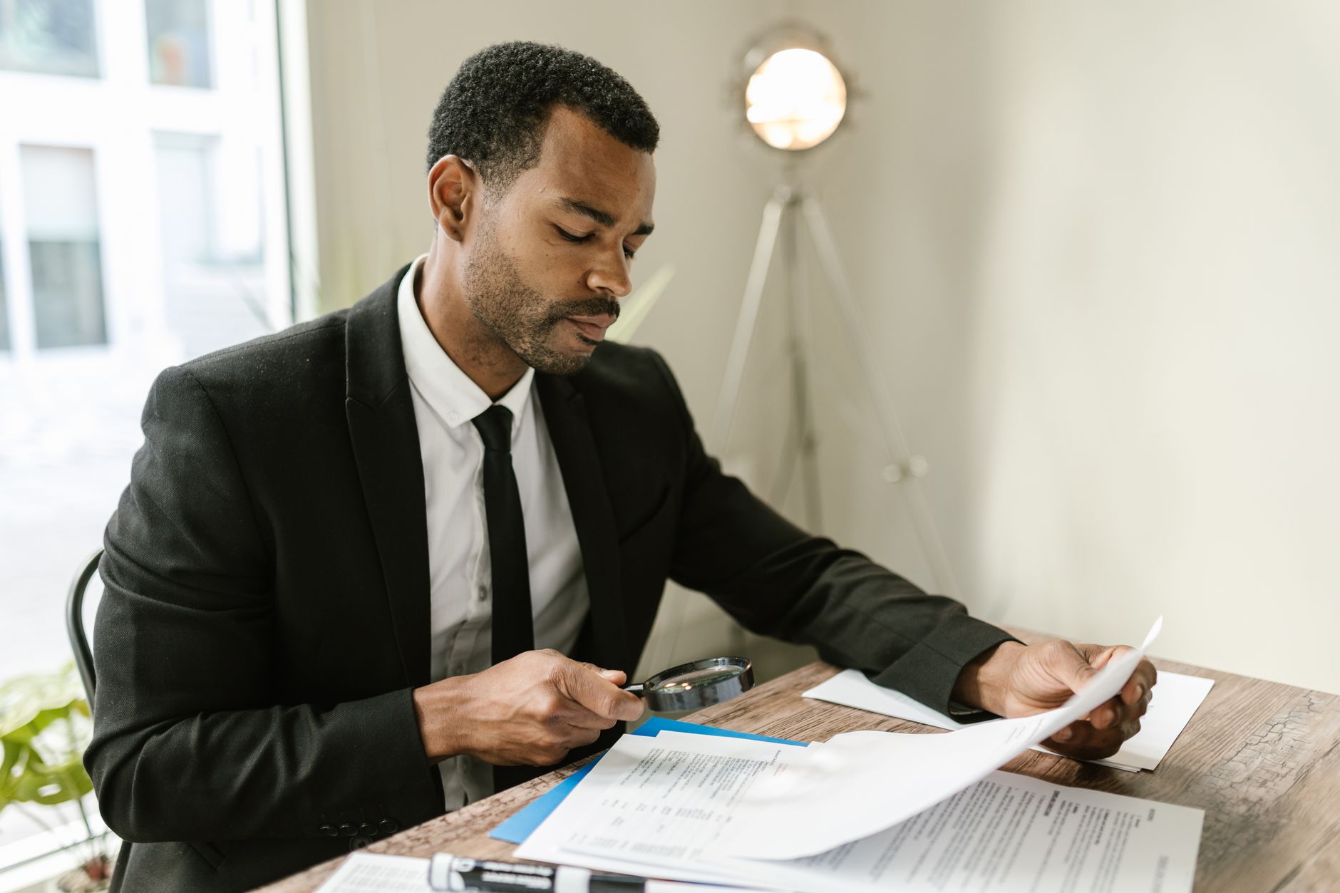 Compliance officer examining import documents with a magnifying glass