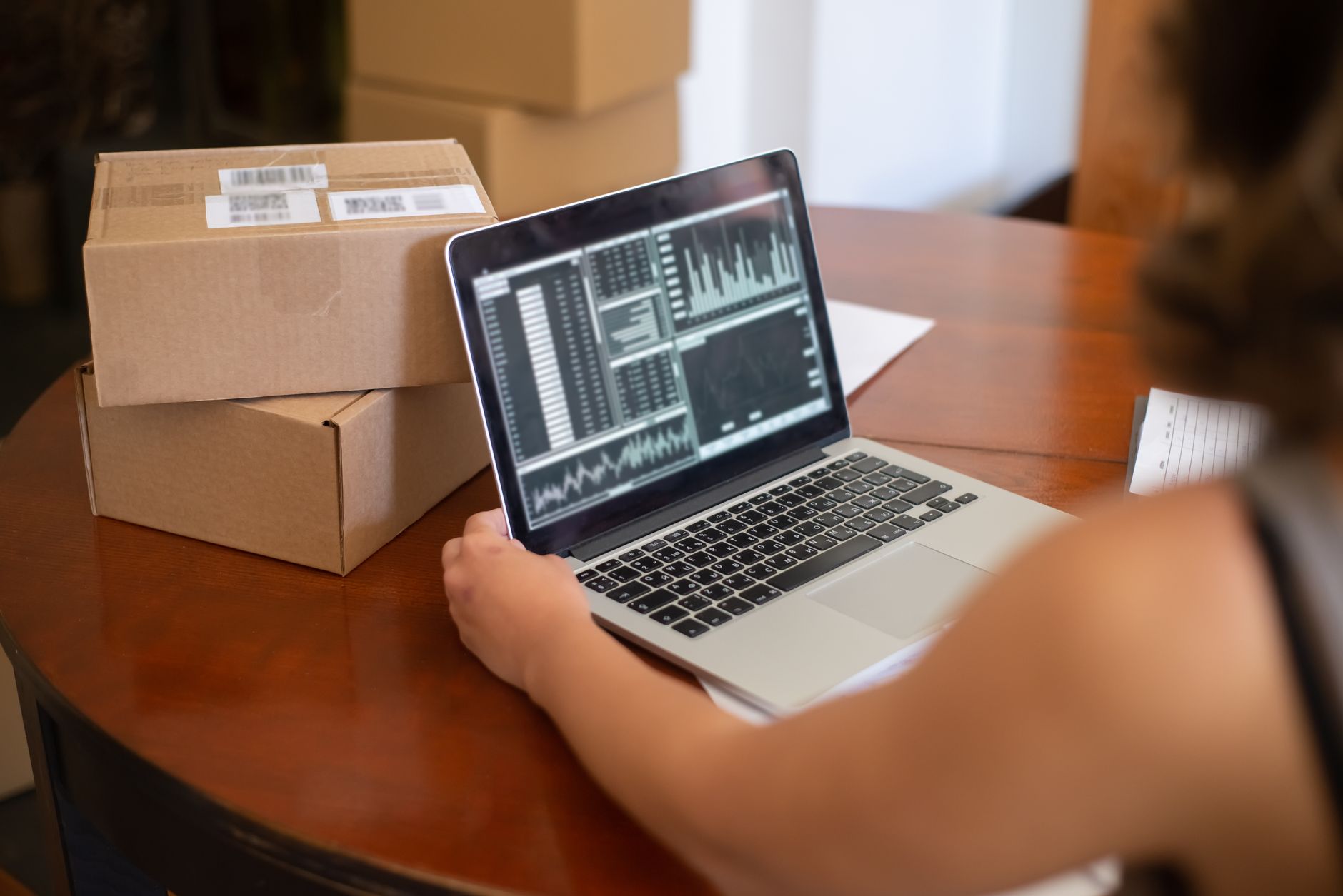 Logistics dashboard on a laptop beside shipped parcels
