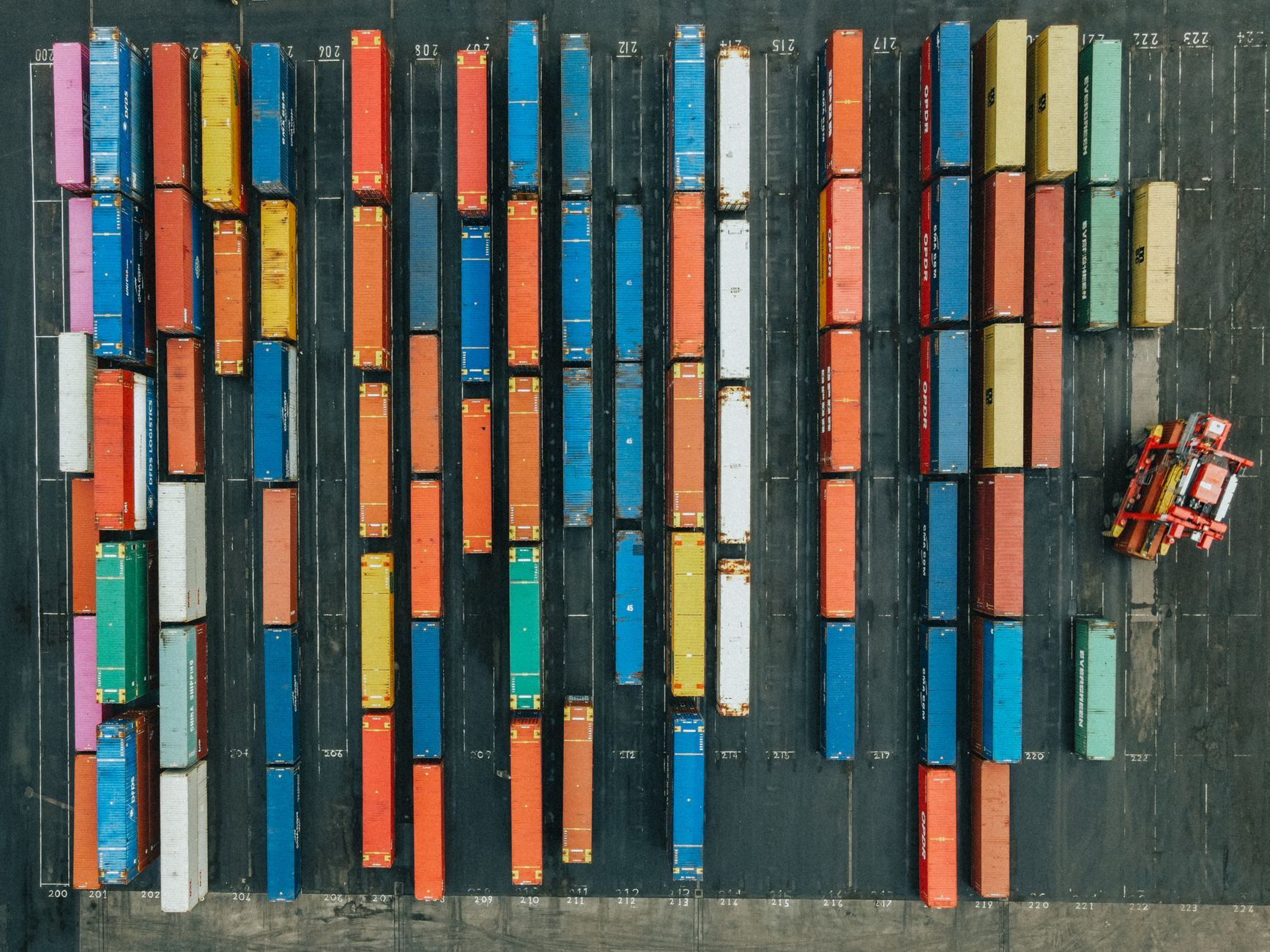Aerial view of containers stacked in rows at a port yard
