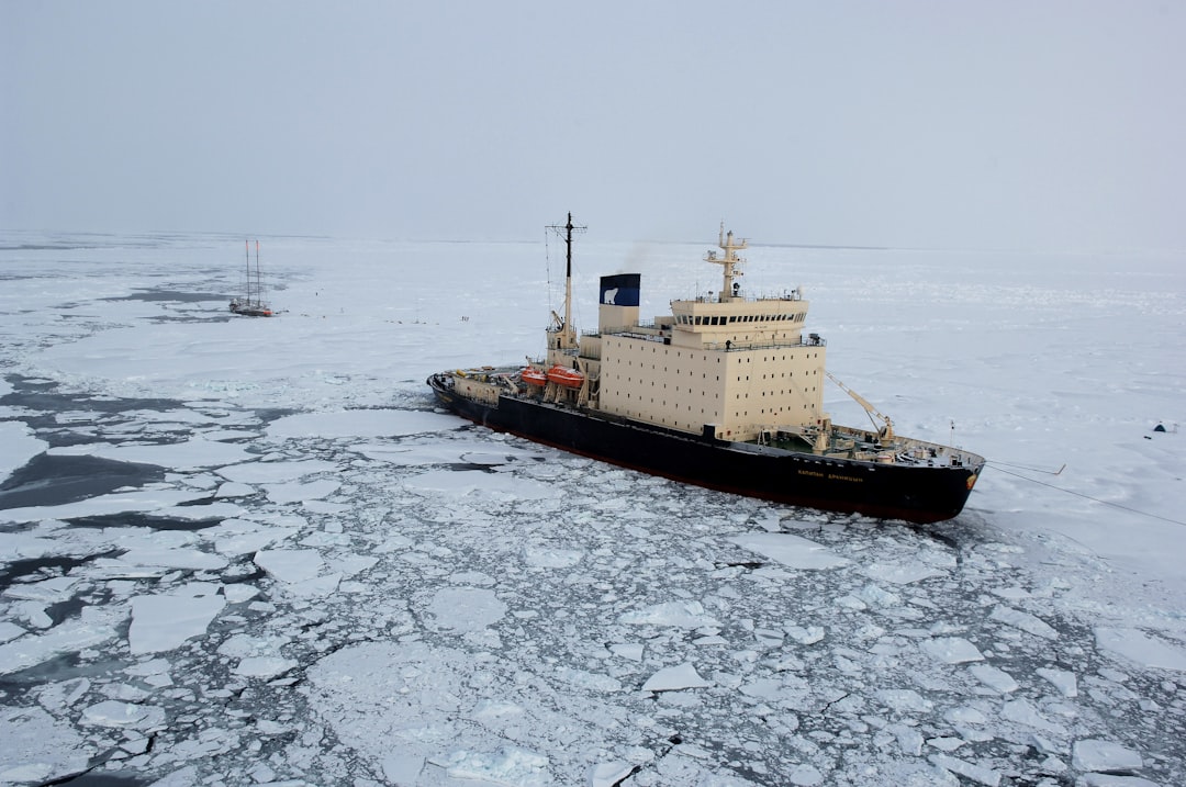 Vessel stopped in a broken ice field under an overcast Arctic sky