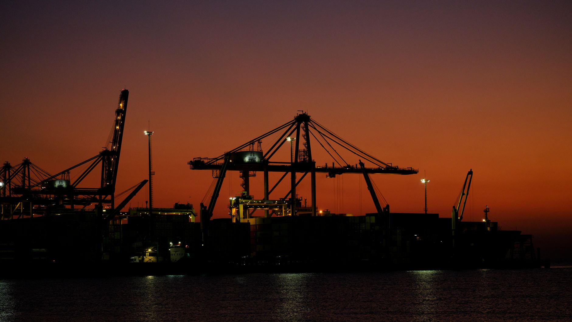 Container port cranes at dusk, evoking Gulf sea gateways in the Saudi and GCC freight corridor