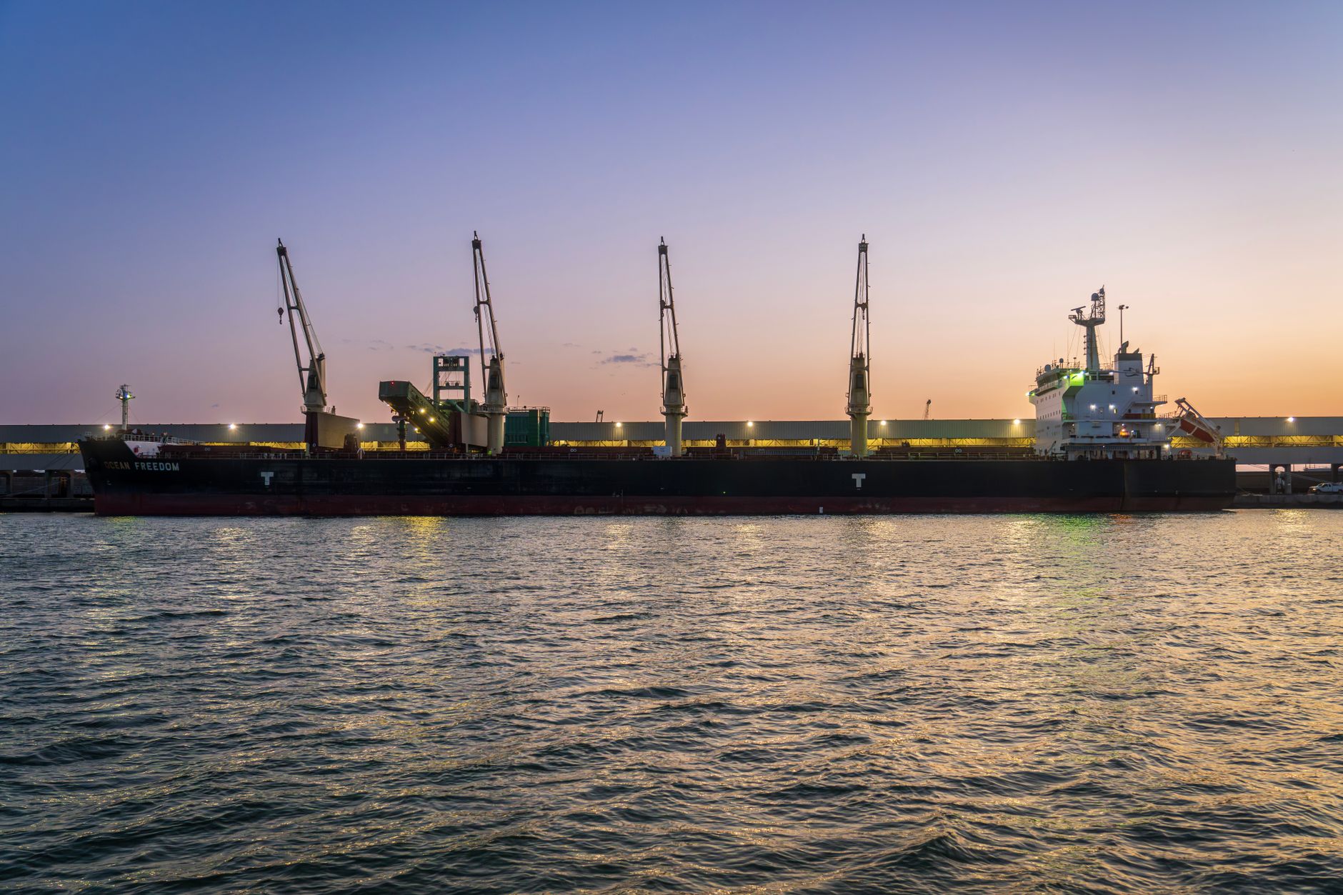 Bulk cargo ship docked at a Red Sea port at dusk