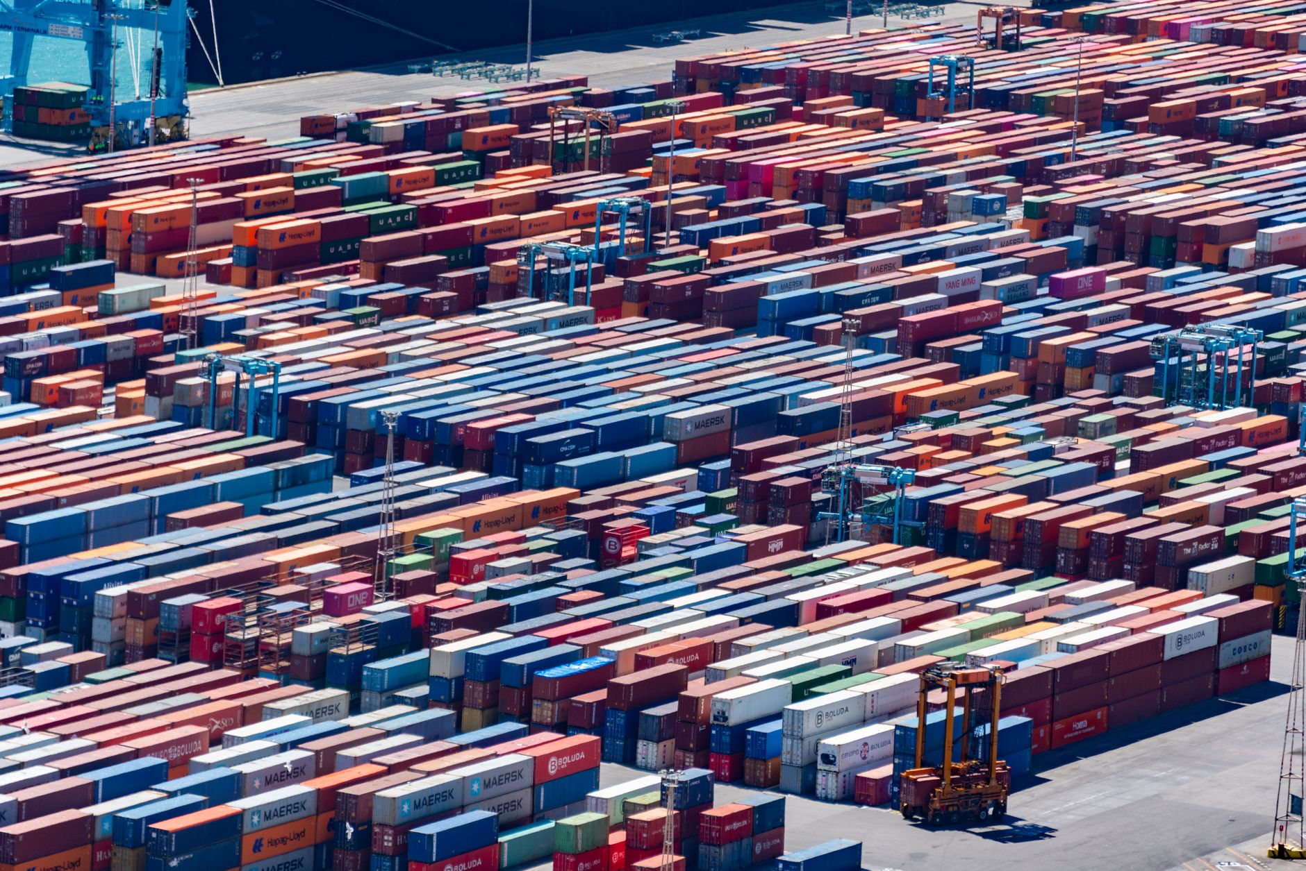 Stacked containers and straddle carriers across a large terminal yard