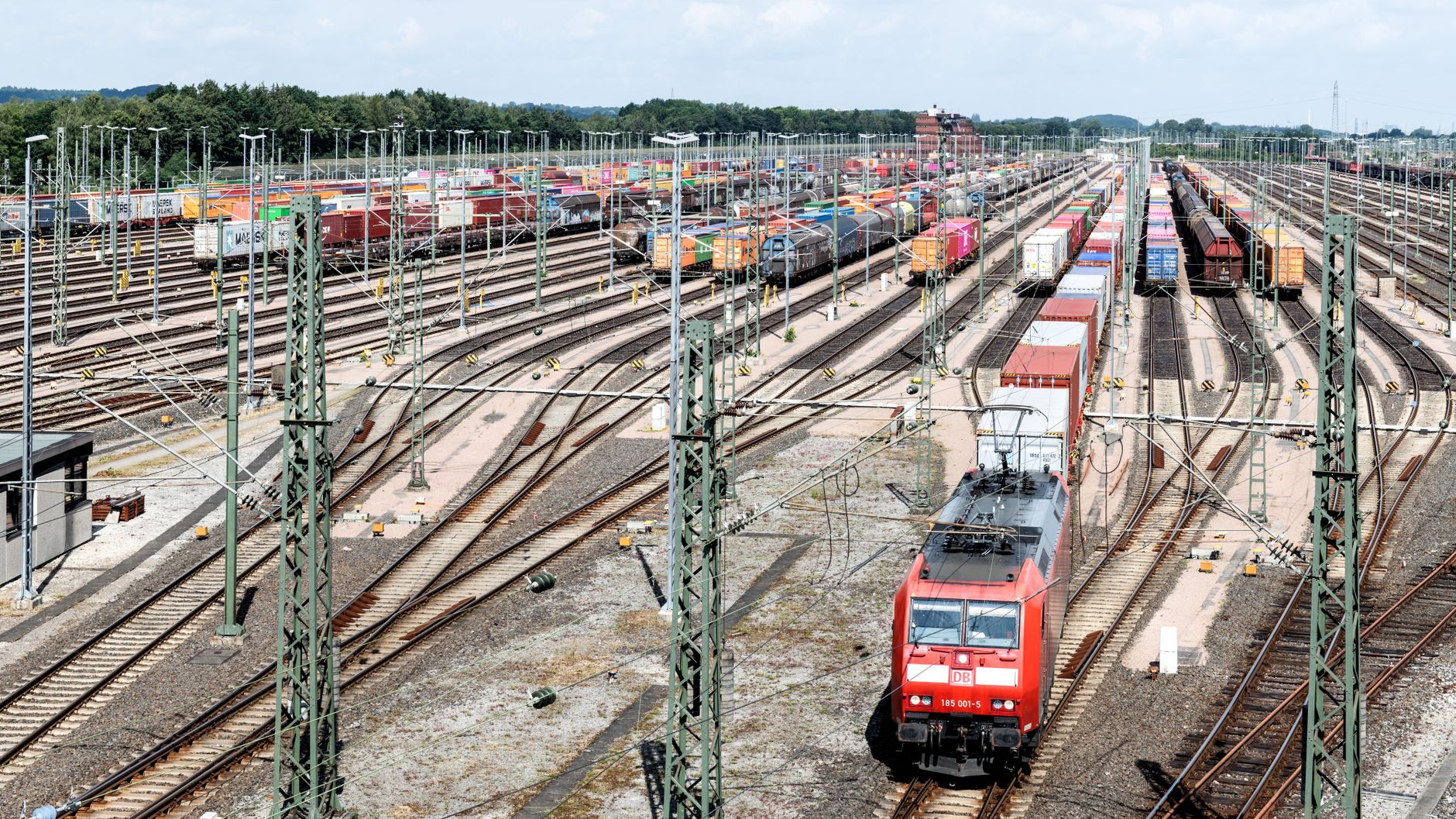 Container trains standing across the tracks of a large rail freight yard