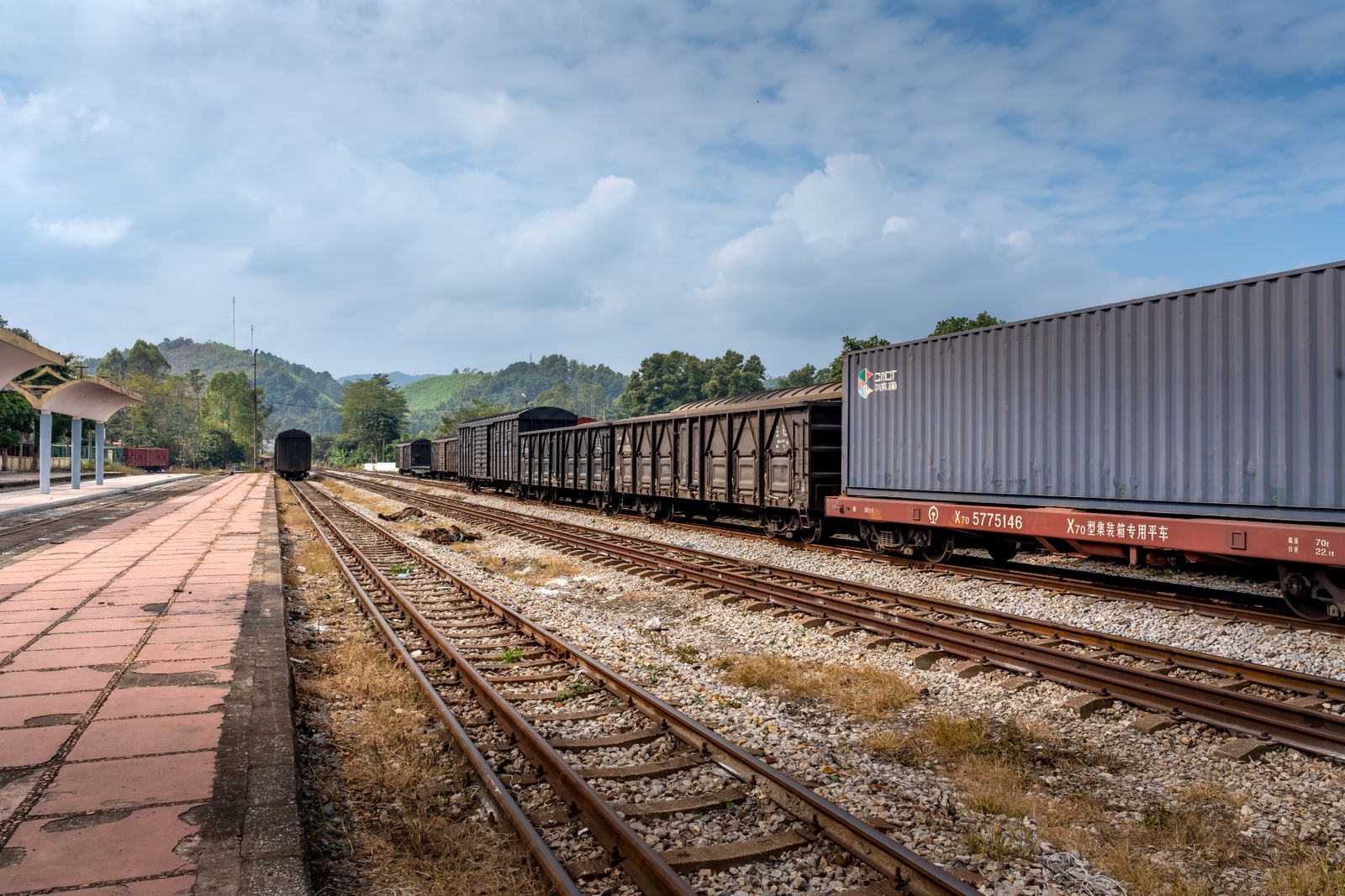 Single track freight line with wagons standing at a rural station